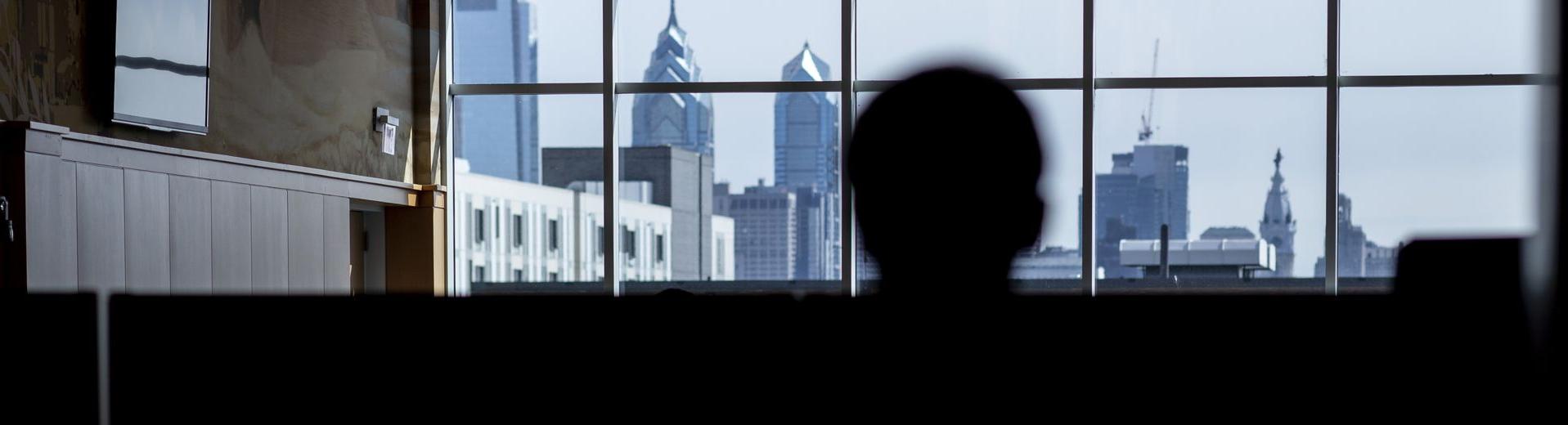 A student looks at the Philadelphia skyline through the windows of a building at 威尼斯赌场网站.